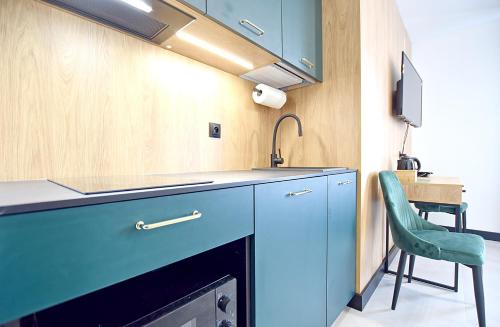 a kitchen with blue cabinets and a sink at Tlenoterapia in Białystok
