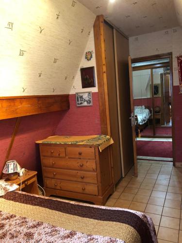 ein Schlafzimmer mit einem Bett und einer Kommode in einem Zimmer in der Unterkunft Yufan in La Ville-du-Bois