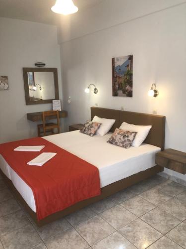 a bedroom with a large bed with a red blanket at Chrisanthi Studios & Apartments in Plakias