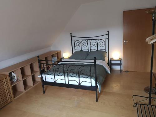 1 dormitorio con 1 cama negra con 2 luces encendidas en Drei Zimmer Appartment mit Küche & Bad, en Weingarten