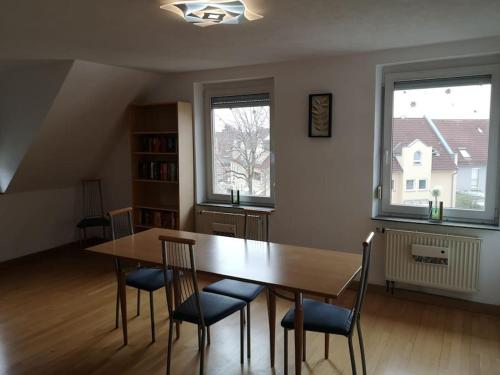 comedor con mesa, sillas y 2 ventanas en Drei Zimmer Appartment mit Küche & Bad, en Weingarten