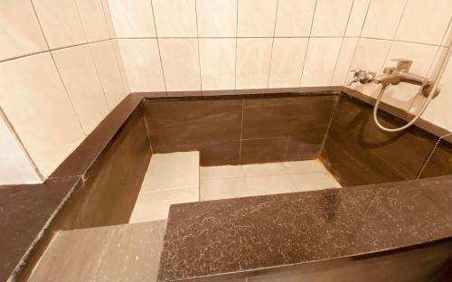 a bathroom with a bath tub with a shower at Beauty Garden Hotel - Jiaoxi in Jiaoxi