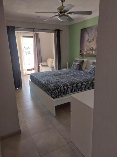 een slaapkamer met een bed en een plafondventilator bij NICE 1 BEDROOM APARTMENT LOS CRISTIANOS in Los Cristianos