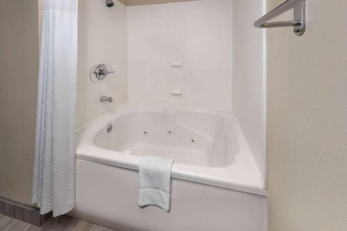 a white bath tub in a white bathroom at Super 8 by Wyndham Copley Akron in Copley
