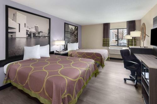 a hotel room with two beds and a desk at Super 8 by Wyndham Copley Akron in Copley