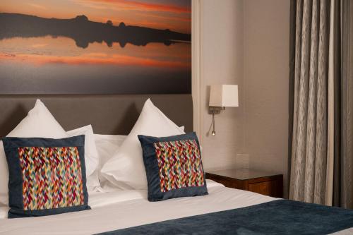 a bedroom with a bed with two pillows at Manor House Country Hotel in Enniskillen