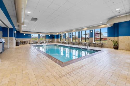 een groot zwembad in een grote ruimte met tafels en stoelen bij Hampton Inn Cape Girardeau I-55 East, MO in Cape Girardeau