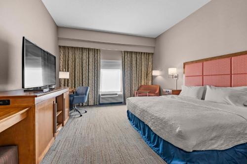 um quarto de hotel com uma cama e uma televisão de ecrã plano em Hampton Inn Cape Girardeau I-55 East, MO em Cape Girardeau