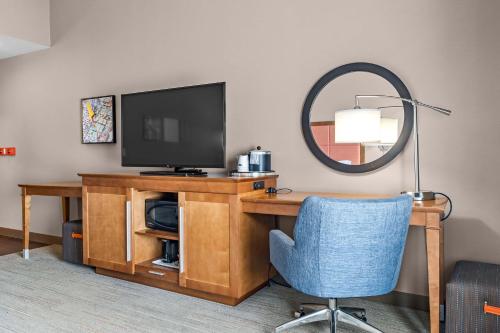 a room with a desk with a television and a chair at Hampton Inn Cape Girardeau I-55 East, MO in Cape Girardeau