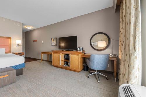 a hotel room with a bed and a desk with a television at Hampton Inn Cape Girardeau I-55 East, MO in Cape Girardeau