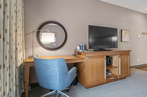 a room with a desk with a television and a chair at Hampton Inn Cape Girardeau I-55 East, MO in Cape Girardeau
