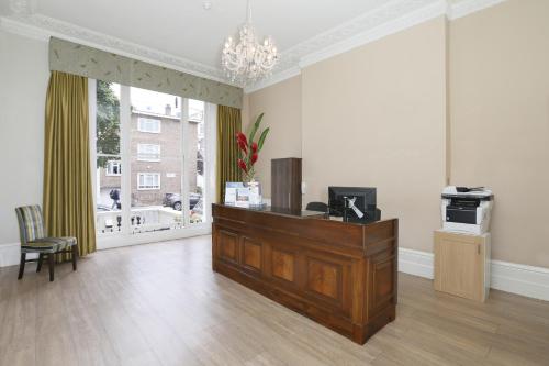 a living room with a dresser and a large window at Hyde Park Boutique Hotel in London