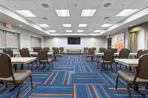 a conference room with tables and chairs and a screen at Hampton Inn Cape Girardeau I-55 East, MO in Cape Girardeau