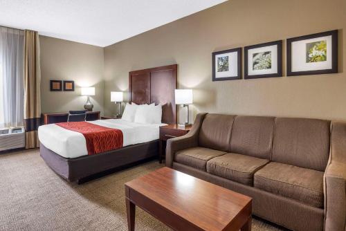 a hotel room with a bed and a couch at Comfort Inn Grain Valley in Grain Valley