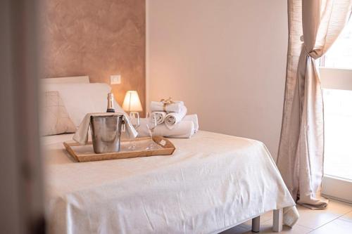 un letto con un vassoio e una bottiglia di vino sopra di Cilento Holiday Village a Montecorice