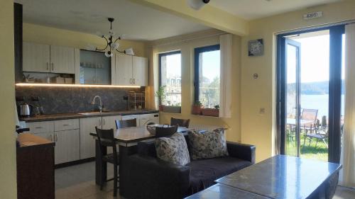 a kitchen and living room with a couch and a table at Къща за гости СИАНА in Dospat