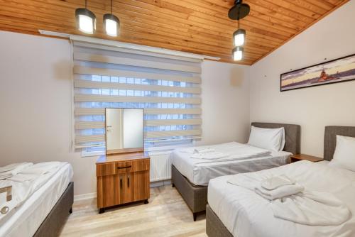 2 camas en una habitación con espejo y lavabo en HAGİA Detached House, en Estambul