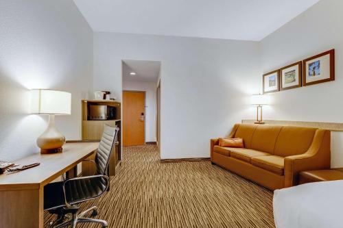 a hotel room with a couch and a chair at Comfort Suites Murfreesboro Shopping District in Murfreesboro