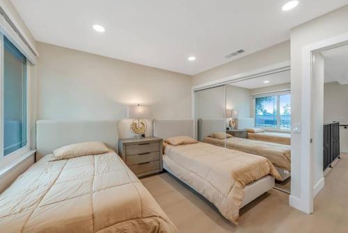 1 Schlafzimmer mit 2 Betten und einem Spiegel in der Unterkunft Luxe Home Steps from Mall and Downtown Escape in San Jose
