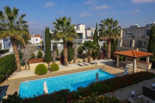 una grande piscina con palme e edifici di Sunset Green 03 a Paphos