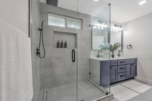 ein Bad mit einer Glasdusche und einem Waschbecken in der Unterkunft Luxe Home Steps from Mall and Downtown Escape in San Jose