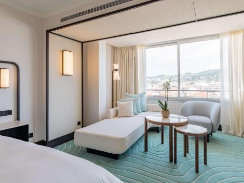 une chambre d'hôtel avec un lit et une table dans l'établissement Mondrian Cannes, à Cannes