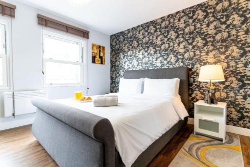 een slaapkamer met een bed en een muur bedekt met bloemenbehang bij Moseley Haven 2 - Bed Luxury in Birmingham