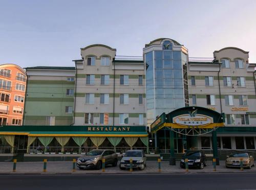 un gran edificio con coches estacionados frente a él en Vila Verde, en Chişinău