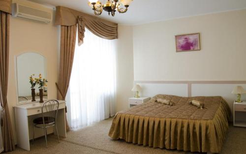 1 dormitorio con cama, escritorio y ventana en Vila Verde, en Chişinău