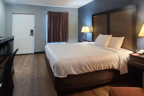 a hotel room with a large bed and a telephone at Econo Lodge in Forest City