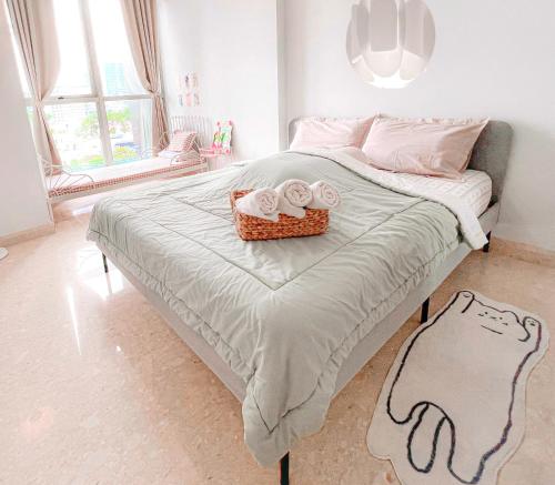 a bedroom with a bed with a tray of towels at Gold Coast PIK Apartments by Host Jess in Jakarta