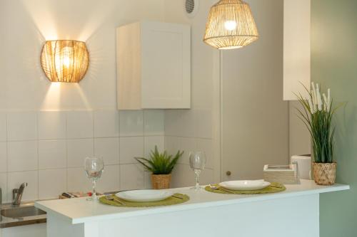 une cuisine avec une table avec deux verres et une lumière dans l'établissement Jungle Paradise-Disney-Free Parking, à Montévrain