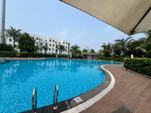 une grande piscine bleue dans un bâtiment dans l'établissement Villa SB03 Road in Vinhome Ocean Park 1, à Gia Lâm Pho