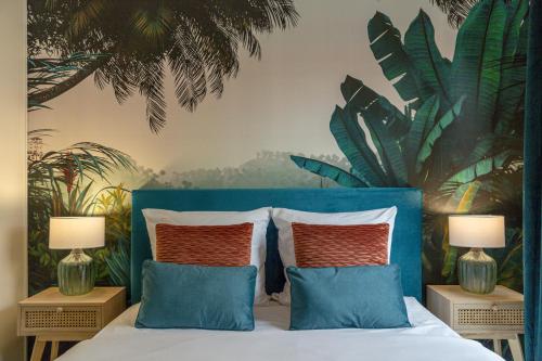 - une chambre avec un lit bleu et 2 tables de nuit dans l'établissement Jungle Paradise-Disney-Free Parking, à Montévrain