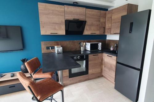 Il comprend une cuisine équipée d'un réfrigérateur, d'une table et de chaises. dans l'établissement Studio de charme en centre-ville, à La Grande Motte