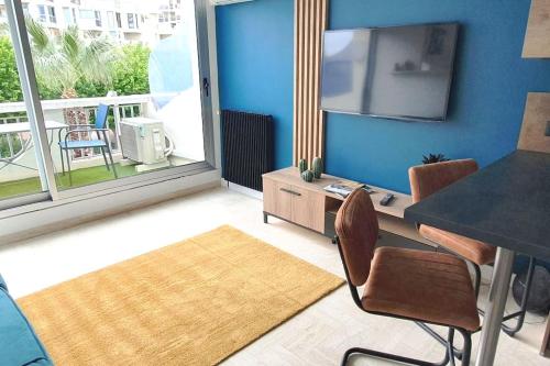 un salon avec une table à manger et une télévision dans l'établissement Studio de charme en centre-ville, à La Grande Motte