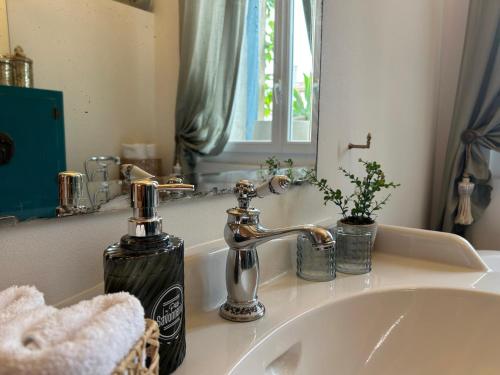 um lavatório de casa de banho com um dispensador de sabão e um espelho em MAISON La BOHEME Spa & Jacuzzi em Vias