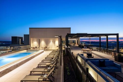 a building with a swimming pool and lounge chairs at Hilton BNA Nashville Airport Terminal in Nashville