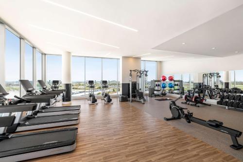 a gym with treadmills and exercise equipment and windows at Hilton BNA Nashville Airport Terminal in Nashville