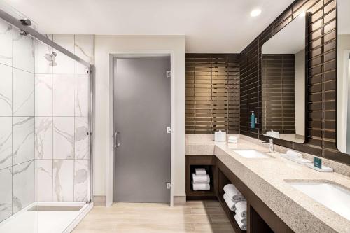 a bathroom with two sinks and a shower at Hilton BNA Nashville Airport Terminal in Nashville