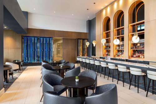 a restaurant with tables and chairs and a bar at Hilton BNA Nashville Airport Terminal in Nashville