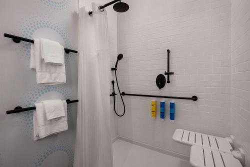 baño blanco con ducha y lavamanos en Tru By Hilton Brooklyn, en Brooklyn