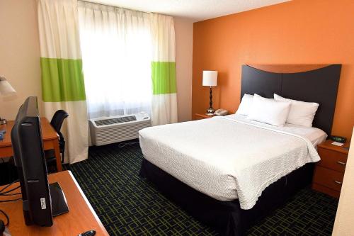 um quarto de hotel com uma cama e uma televisão em AmericInn by Wyndham Topeka em Topeka