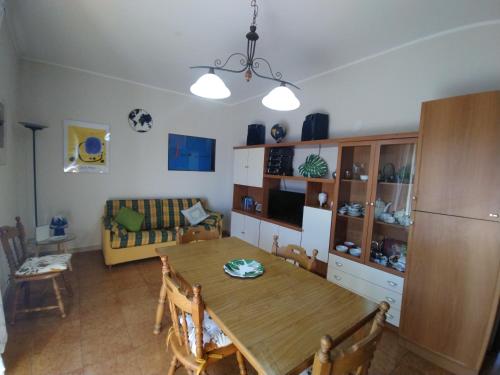 eine Küche und ein Esszimmer mit einem Holztisch in der Unterkunft Bilocale Jonio in Mascali