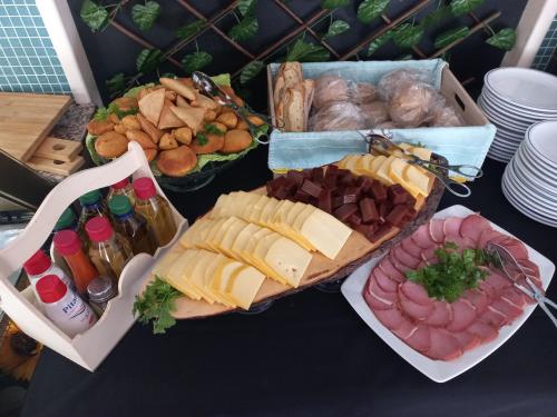 a table topped with different types of meats and cheese at Hotel Lagar do Lago in Castanheira de Pêra