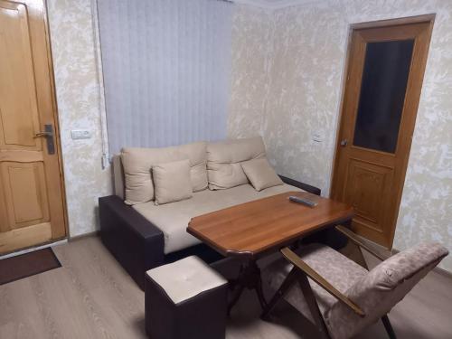 a living room with a couch and a wooden table at Гостевой дом in Maksim Gorʼkiy