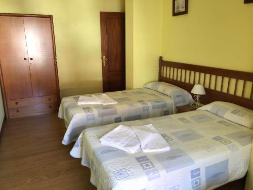 1 dormitorio con 2 camas y armario con lámpara en Apartamentos de la Hoz, en Isla
