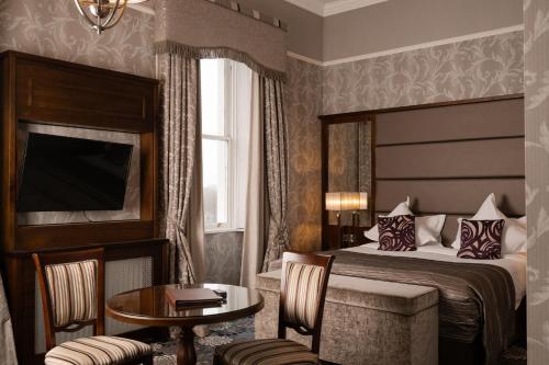 a hotel room with a bed and a table at Manor House Country Hotel in Enniskillen