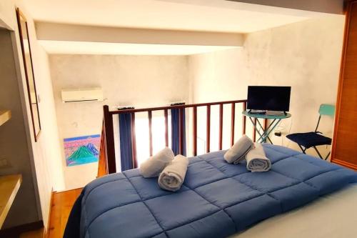 een groot blauw bed in een kamer met een balkon bij Terrazza Bonapace Partenope in Napels