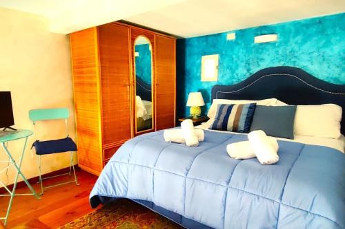 een blauwe slaapkamer met een bed met 2 witte kussens bij Terrazza Bonapace Partenope in Napels